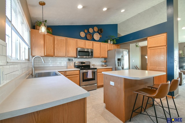 kitchen featuring a kitchen island, lofted ceiling, a sink, stainless steel appliances, and a kitchen bar