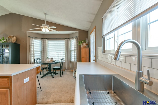 kitchen featuring light carpet, a healthy amount of sunlight, ceiling fan, and a sink