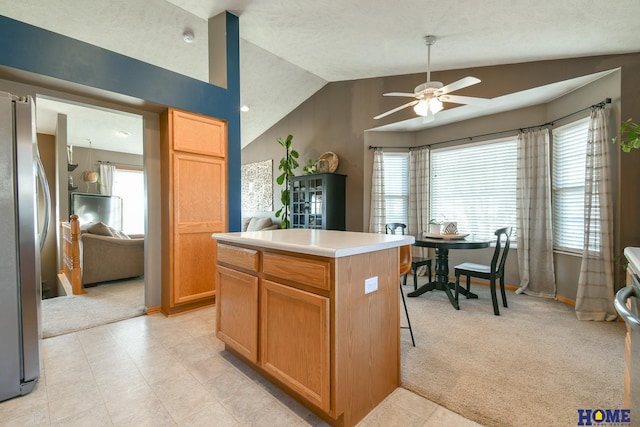 kitchen featuring light colored carpet, ceiling fan, vaulted ceiling, and freestanding refrigerator