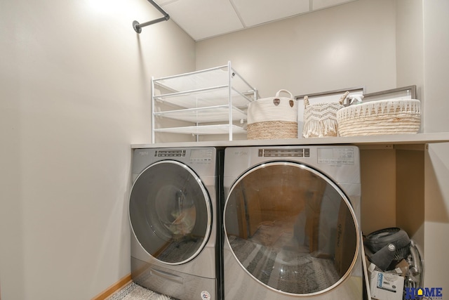 clothes washing area featuring washer and clothes dryer, laundry area, and baseboards