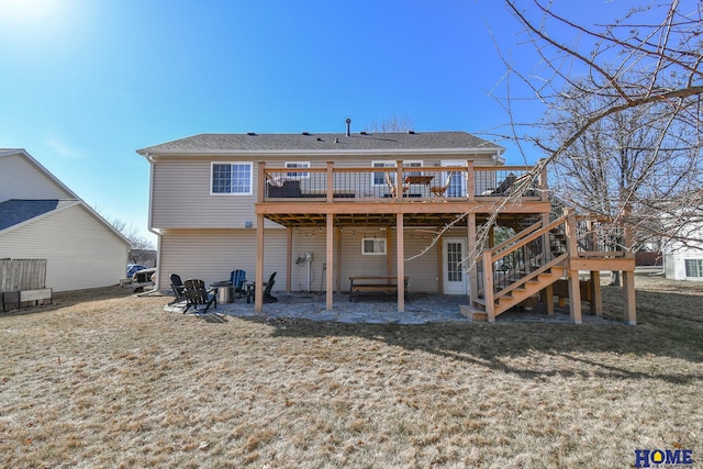 back of property with a wooden deck, a yard, and stairway