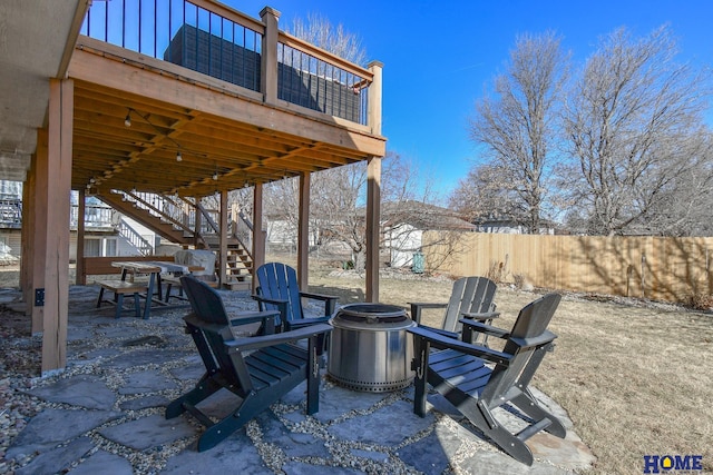 view of patio with stairway, a fire pit, and fence