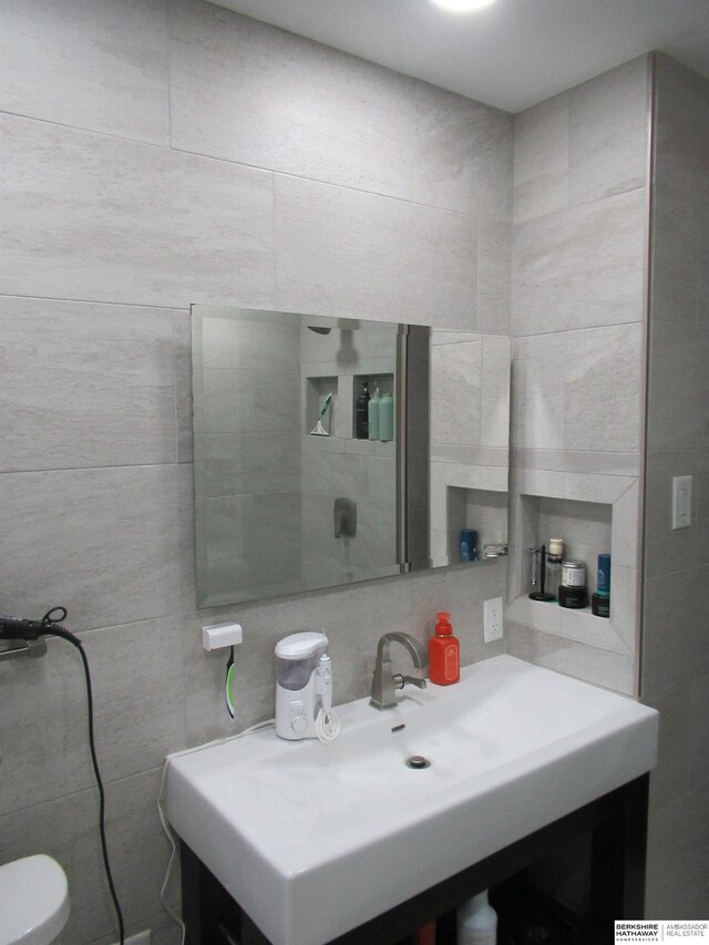 bathroom featuring vanity, tile walls, toilet, and backsplash