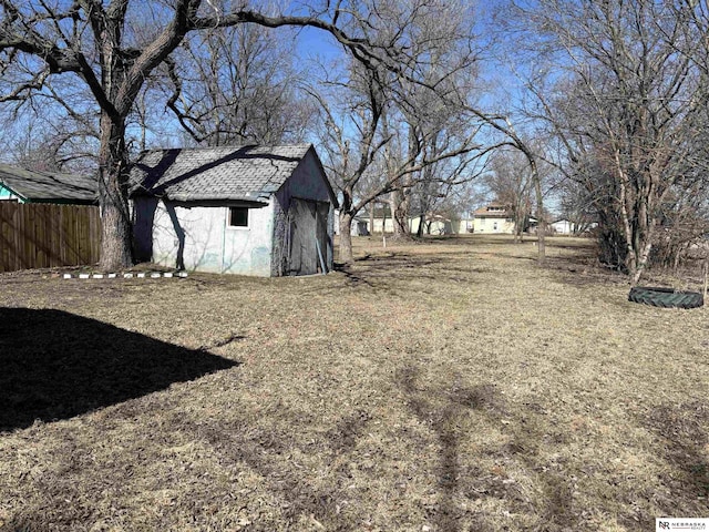 view of yard with an outbuilding, a shed, and fence