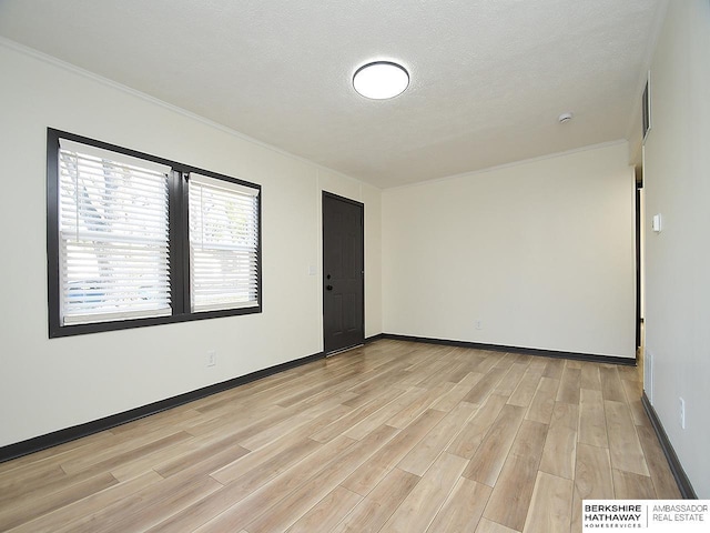 unfurnished room with baseboards, light wood-style floors, and a textured ceiling