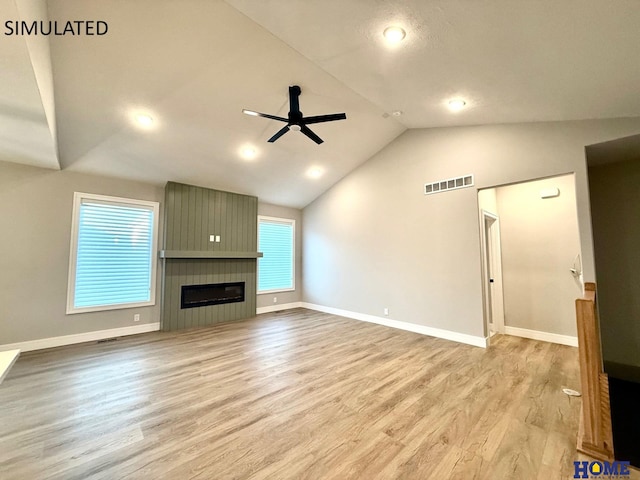 unfurnished living room with ceiling fan, a fireplace, visible vents, wood finished floors, and lofted ceiling