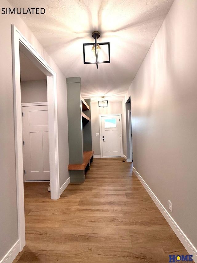 doorway to outside with light wood finished floors and baseboards