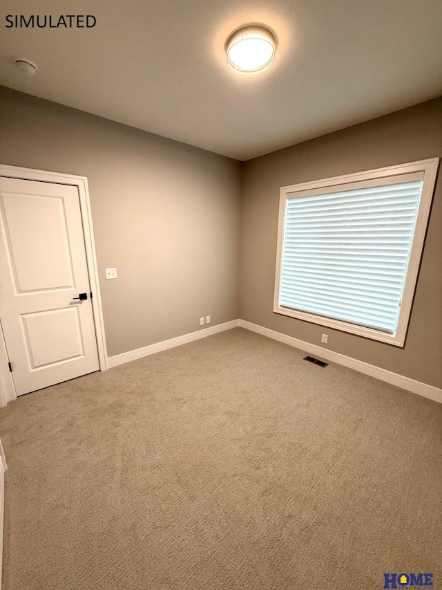 empty room featuring visible vents, baseboards, and carpet floors