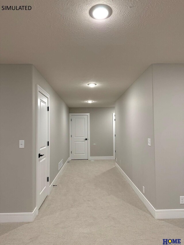 corridor featuring visible vents, baseboards, light carpet, and a textured ceiling