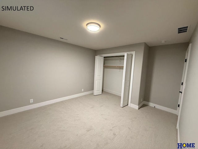 unfurnished bedroom featuring visible vents, baseboards, a closet, and light carpet