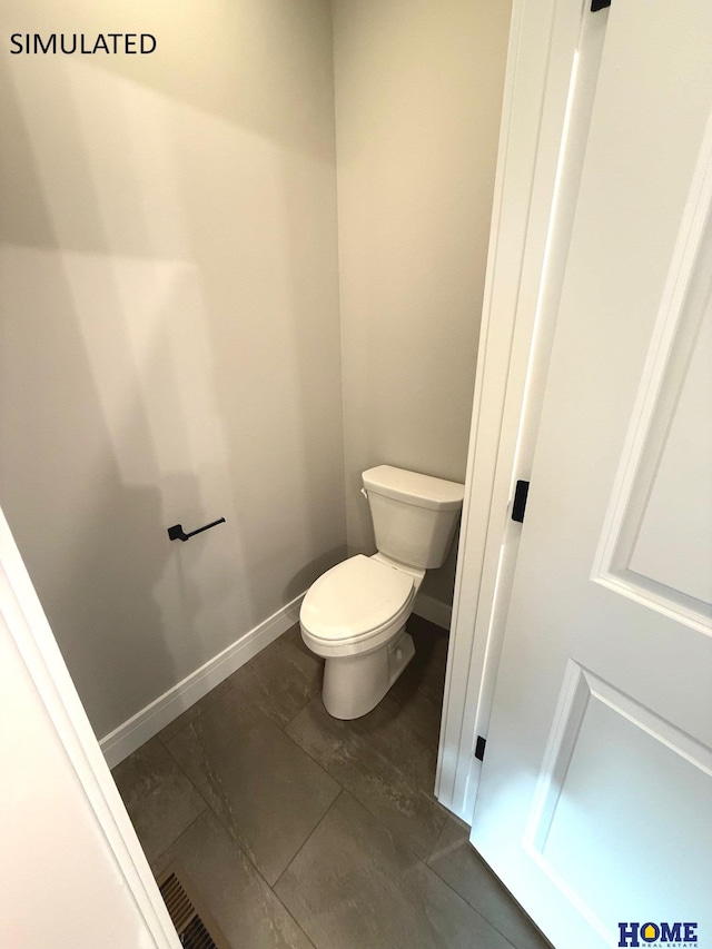 bathroom with baseboards and toilet