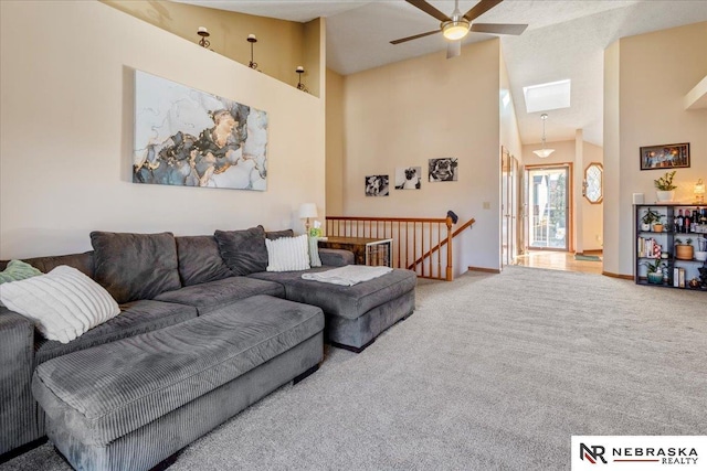 living area featuring carpet floors, high vaulted ceiling, and ceiling fan