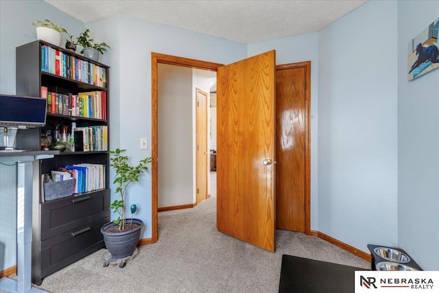 sitting room featuring baseboards, a textured ceiling, and carpet flooring