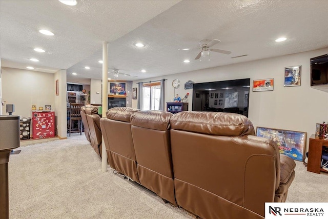 living area with a textured ceiling, recessed lighting, a ceiling fan, and light carpet