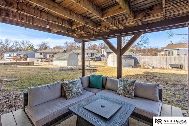 view of patio featuring an outbuilding, an outdoor living space, a storage unit, and a fenced backyard