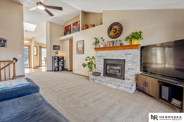 living area featuring light carpet, high vaulted ceiling, a fireplace, baseboards, and ceiling fan