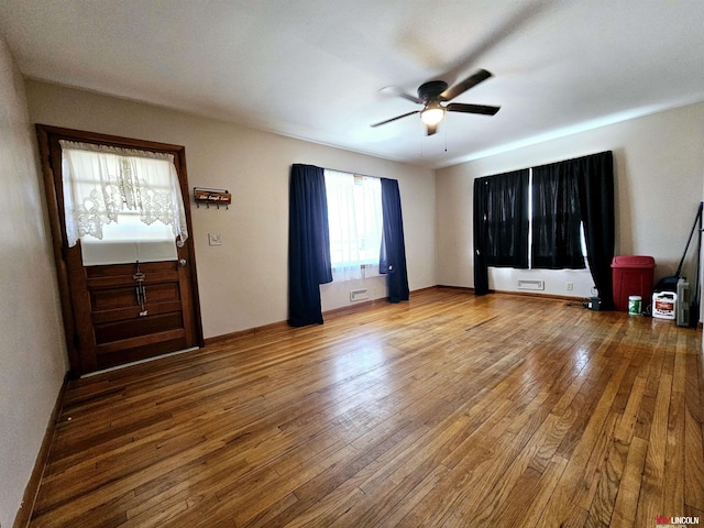 interior space with a ceiling fan and hardwood / wood-style flooring