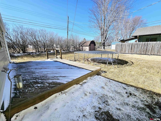 view of yard featuring a wooden deck, a trampoline, and fence