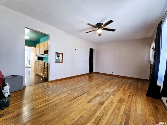 unfurnished living room with light wood-style flooring, baseboards, and ceiling fan