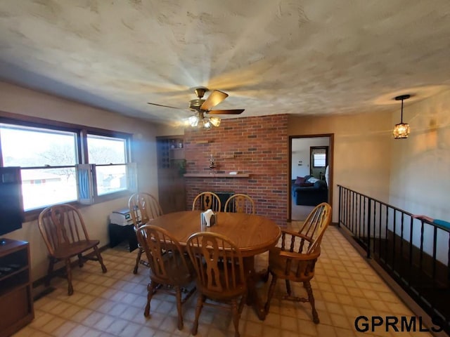 dining area featuring light floors and a brick fireplace