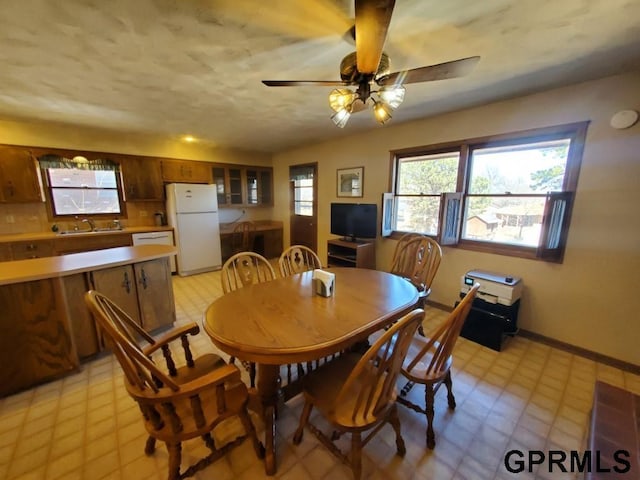 dining room with light floors, baseboards, and ceiling fan