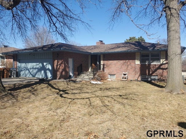 view of front of house featuring brick siding, an attached garage, a chimney, and a front lawn