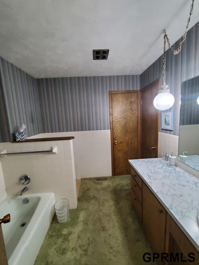 bathroom with a bath, visible vents, wallpapered walls, and vanity