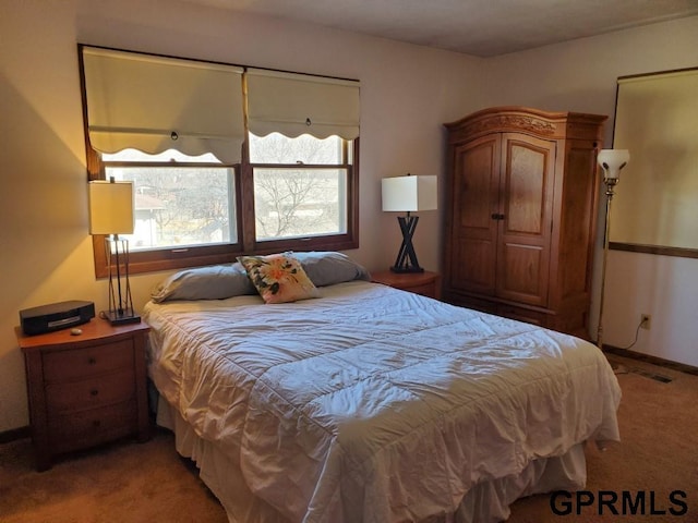 bedroom with baseboards and light colored carpet