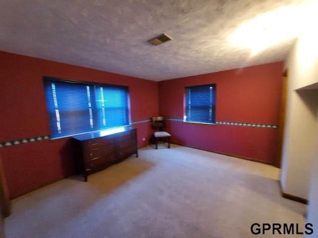 interior space featuring visible vents, carpet flooring, and a textured ceiling