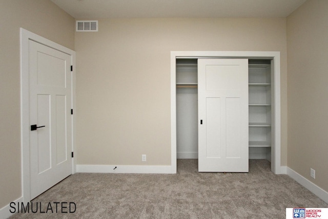 unfurnished bedroom featuring visible vents, carpet floors, baseboards, and a closet