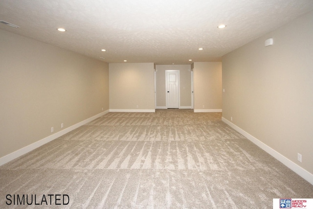 spare room with a textured ceiling, recessed lighting, visible vents, and baseboards