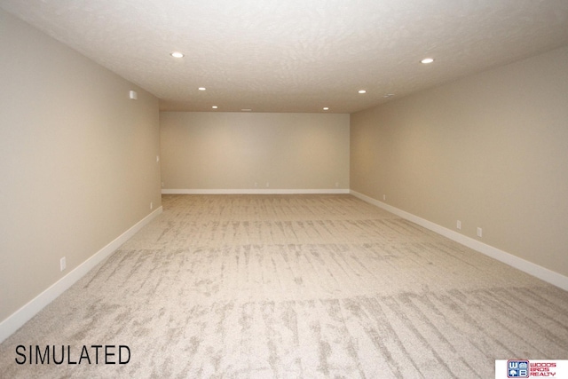 unfurnished room with recessed lighting, a textured ceiling, light colored carpet, and baseboards