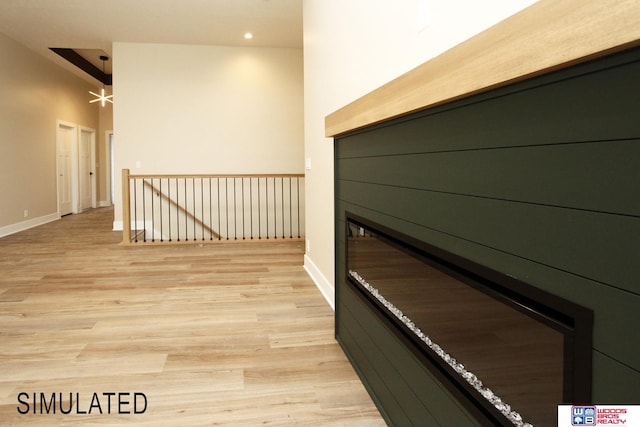 hall with recessed lighting, baseboards, an upstairs landing, and light wood-style floors