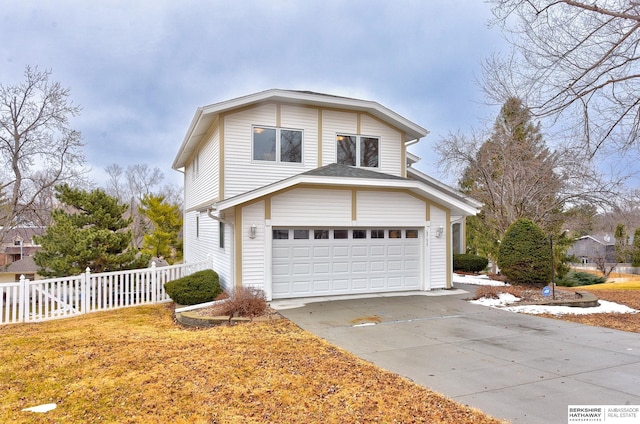 view of front of house featuring concrete driveway and fence