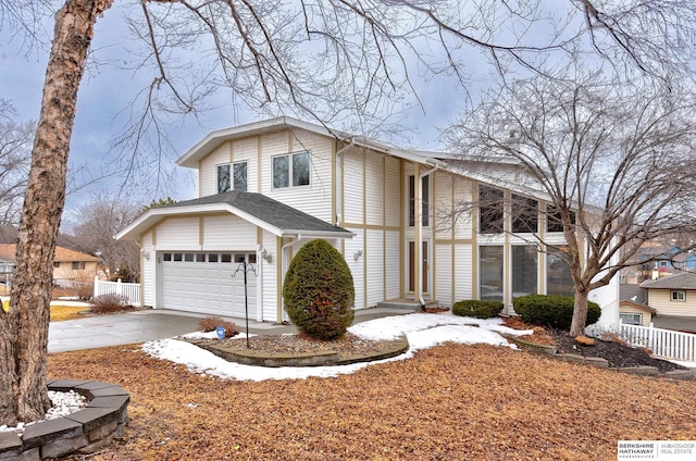 view of front of house with concrete driveway, fence, and a garage