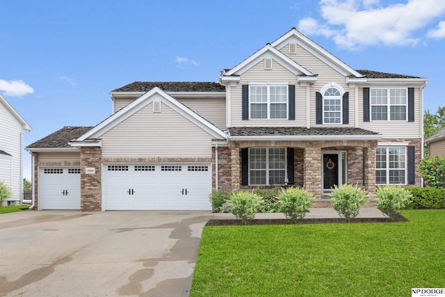 traditional-style home featuring brick siding, an attached garage, concrete driveway, and a front yard