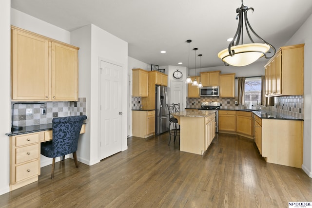 kitchen with a kitchen island, dark wood-type flooring, a breakfast bar area, built in desk, and stainless steel appliances