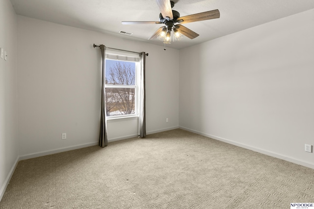 spare room with visible vents, light carpet, baseboards, and ceiling fan