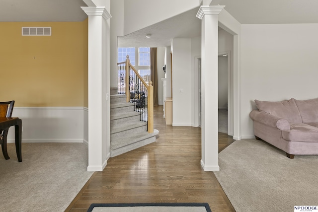 interior space with visible vents, wood finished floors, stairway, decorative columns, and baseboards