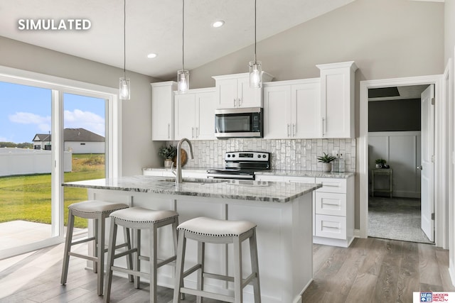 kitchen with light stone counters, tasteful backsplash, light wood-style floors, and appliances with stainless steel finishes