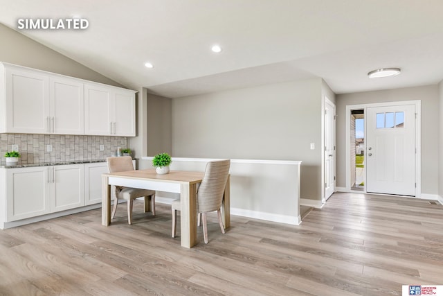 dining space featuring vaulted ceiling, recessed lighting, light wood-style floors, and baseboards