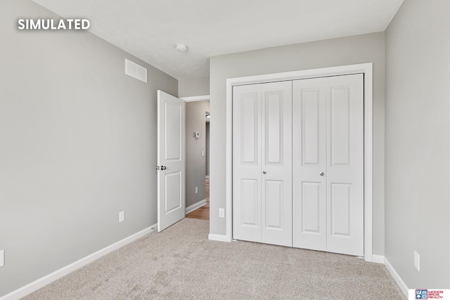 unfurnished bedroom featuring a closet, visible vents, baseboards, and carpet floors