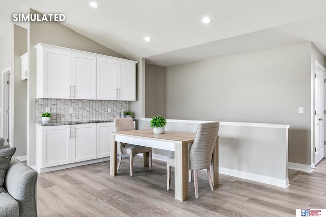 dining space with recessed lighting, light wood-type flooring, baseboards, and vaulted ceiling