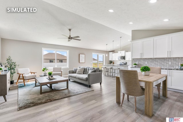 interior space with baseboards, ceiling fan, vaulted ceiling, recessed lighting, and light wood-style flooring