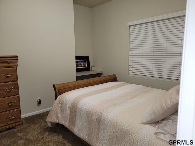 bedroom featuring baseboards and dark colored carpet