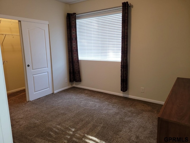 unfurnished bedroom with baseboards, carpet floors, and a closet