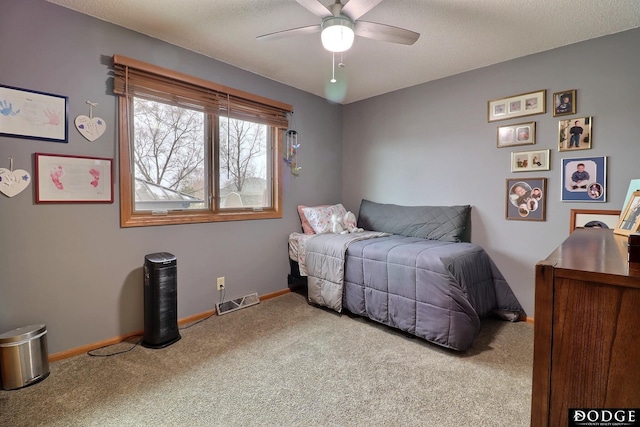 carpeted bedroom with ceiling fan and baseboards