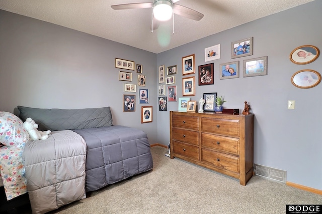 carpeted bedroom featuring baseboards, visible vents, and a textured ceiling