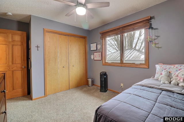 bedroom featuring a textured ceiling, carpet, a closet, and baseboards