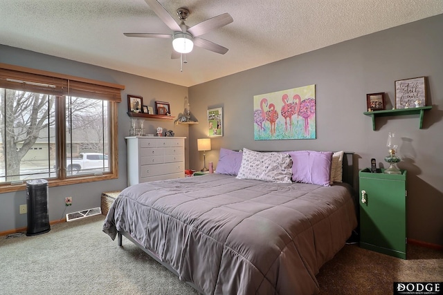 carpeted bedroom featuring visible vents, baseboards, a textured ceiling, and a ceiling fan